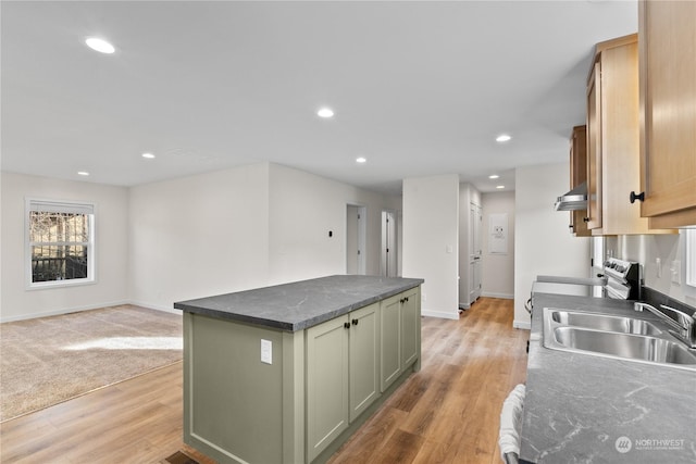 kitchen with sink, green cabinetry, ventilation hood, a center island, and light hardwood / wood-style flooring