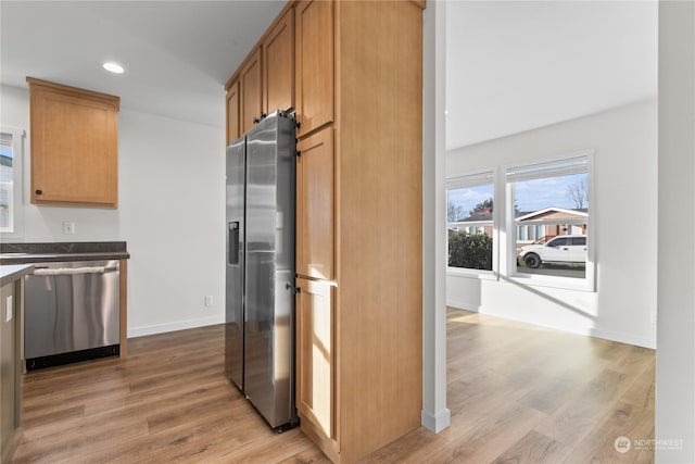 kitchen featuring appliances with stainless steel finishes and light hardwood / wood-style floors