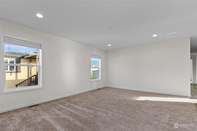 unfurnished room with a wealth of natural light and light colored carpet