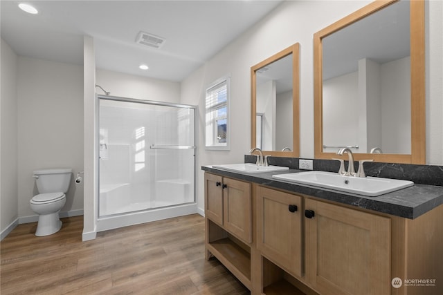 bathroom featuring vanity, wood-type flooring, toilet, and walk in shower