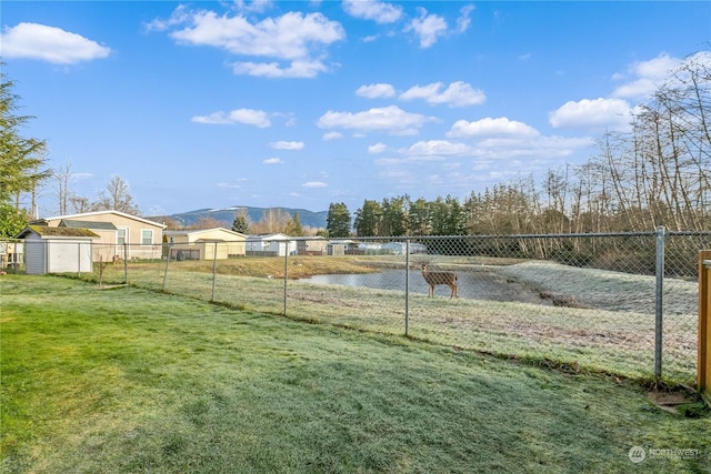 view of yard with a storage shed and a water and mountain view