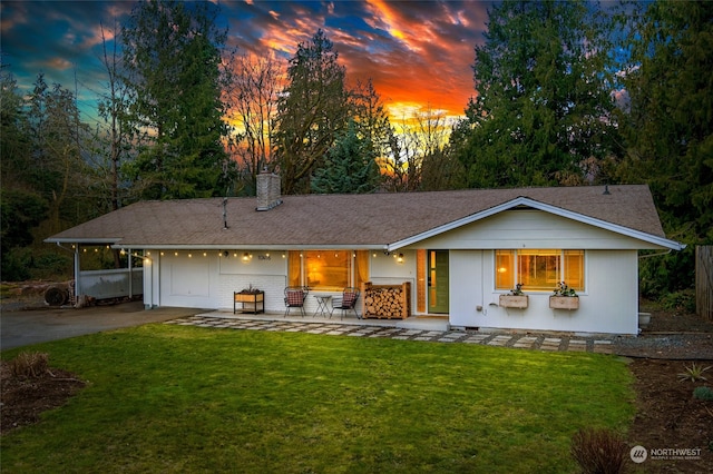 back house at dusk featuring a yard