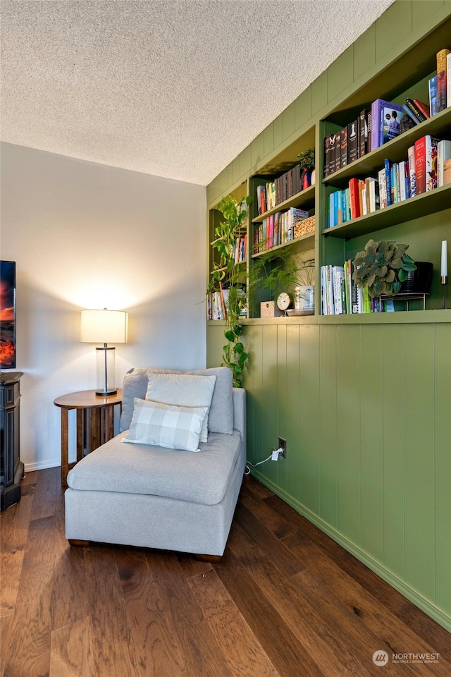 sitting room featuring dark hardwood / wood-style flooring and a textured ceiling