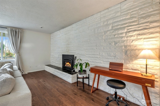 office featuring a fireplace, dark hardwood / wood-style flooring, and a textured ceiling