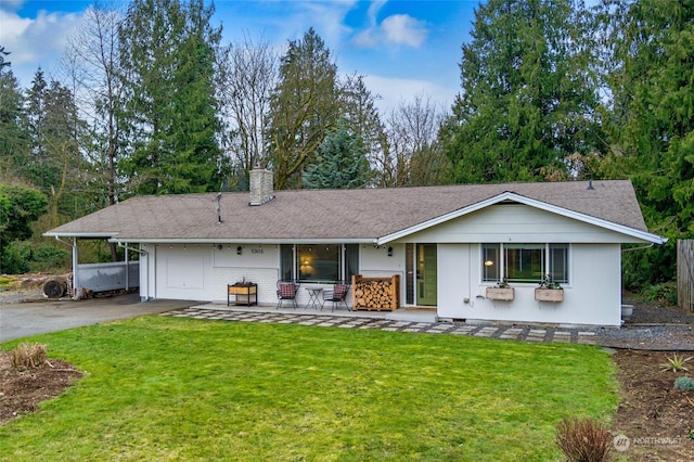 back of house featuring a carport and a yard