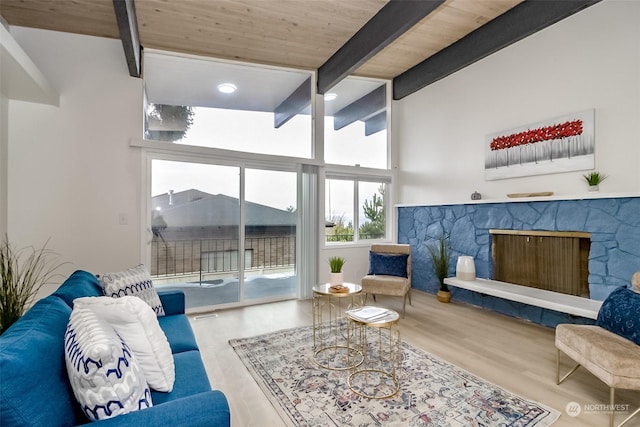 living room with wood ceiling, hardwood / wood-style flooring, a fireplace, and lofted ceiling with beams