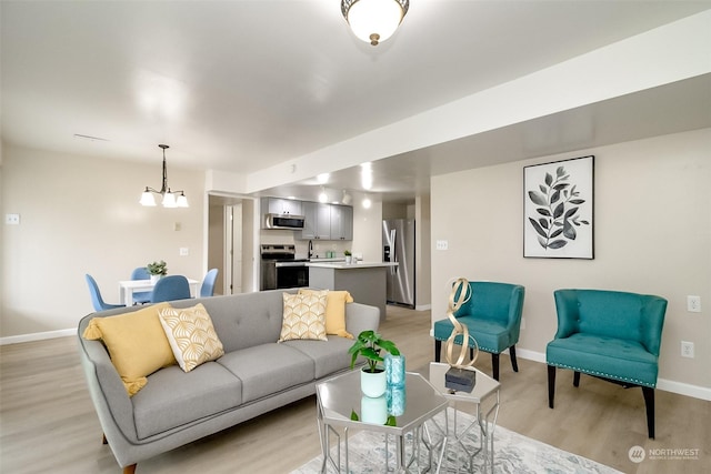 living room with a chandelier and light hardwood / wood-style flooring