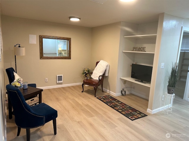 living area featuring heating unit and light hardwood / wood-style flooring