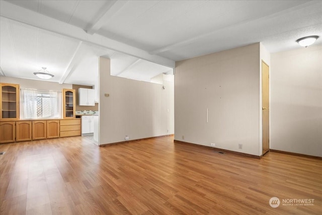 unfurnished living room with lofted ceiling with beams and light hardwood / wood-style flooring