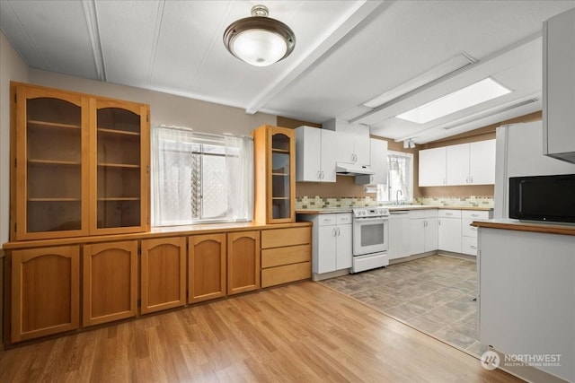 kitchen with a skylight, white electric stove, white cabinetry, sink, and light hardwood / wood-style flooring