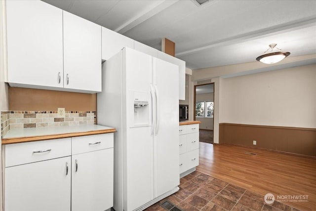 kitchen with white cabinetry, dark wood-type flooring, decorative backsplash, and white fridge with ice dispenser