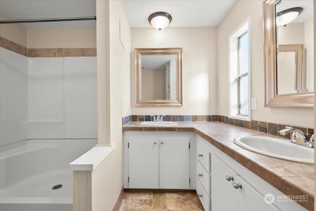 bathroom featuring walk in shower and vanity