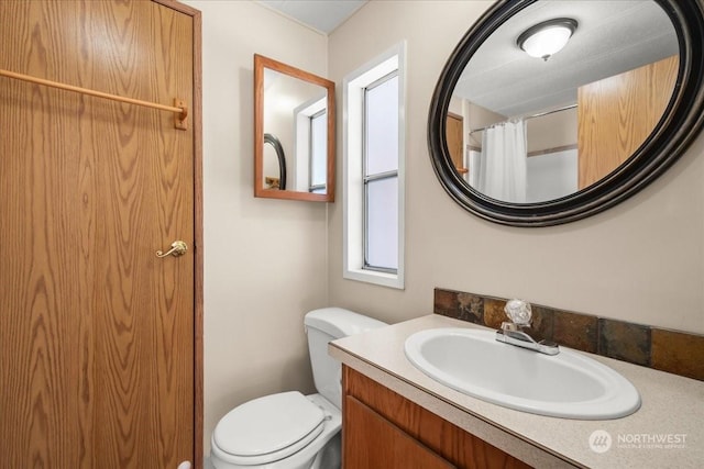 bathroom with vanity, toilet, and walk in shower