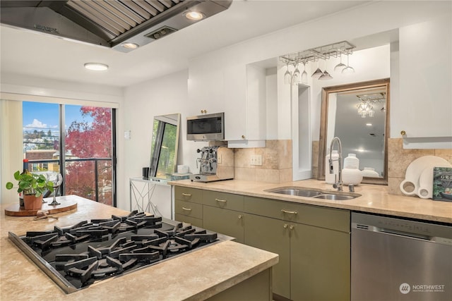 kitchen with appliances with stainless steel finishes, sink, backsplash, green cabinetry, and plenty of natural light