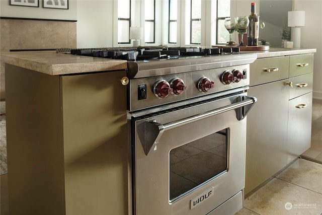 kitchen featuring light tile patterned flooring and luxury stove