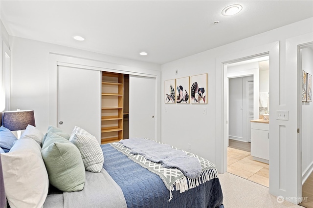 bedroom featuring light colored carpet and a closet