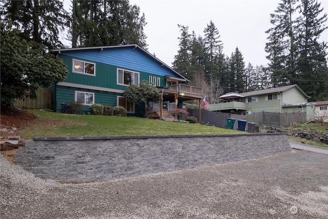 front facade featuring a front yard and a deck