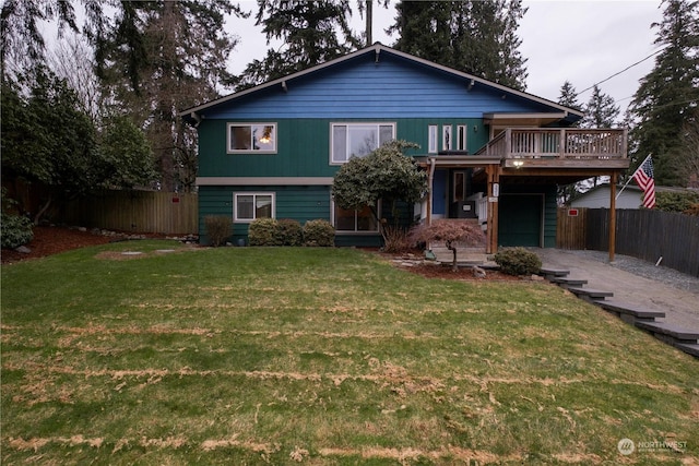 view of front of home with a wooden deck, a garage, and a front lawn