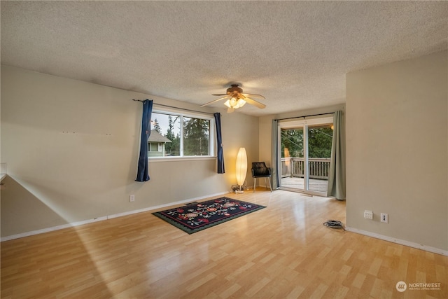 unfurnished room featuring ceiling fan, a healthy amount of sunlight, a textured ceiling, and light wood-type flooring