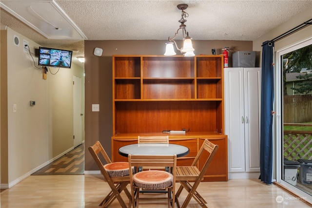 dining area featuring light hardwood / wood-style flooring and a textured ceiling