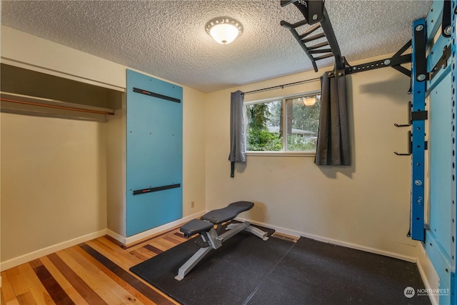 workout area with wood-type flooring and a textured ceiling