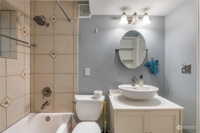 full bathroom with vanity, tiled shower / bath, and toilet