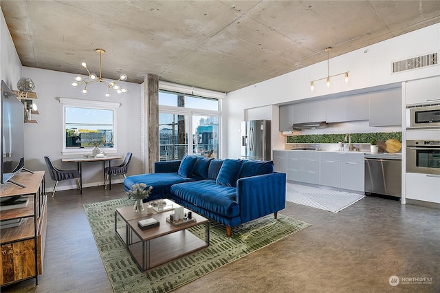 living room featuring sink and a notable chandelier