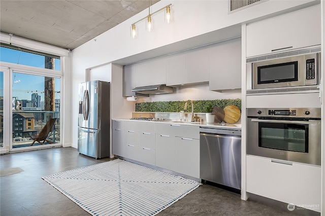 kitchen with appliances with stainless steel finishes, sink, white cabinets, and dark hardwood / wood-style flooring