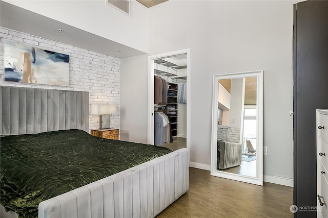 bedroom with dark wood-type flooring, a spacious closet, radiator, and a closet