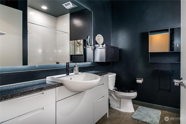 bathroom featuring vanity, a shower, and toilet