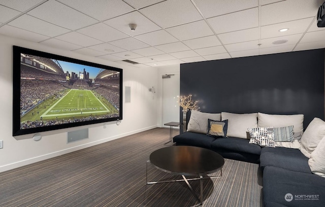 carpeted home theater featuring a drop ceiling