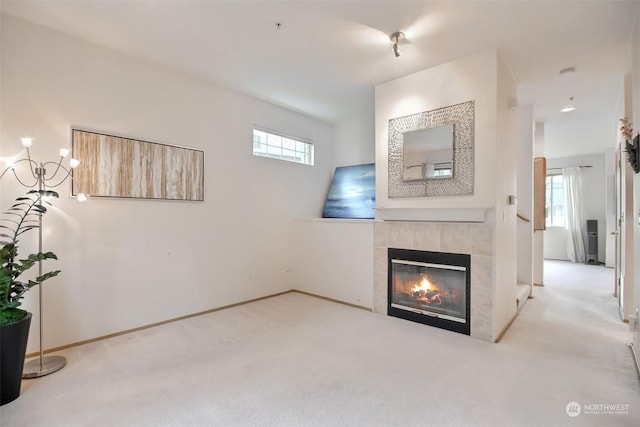 carpeted living area featuring baseboards and a tile fireplace