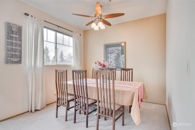 carpeted dining area featuring baseboards and ceiling fan