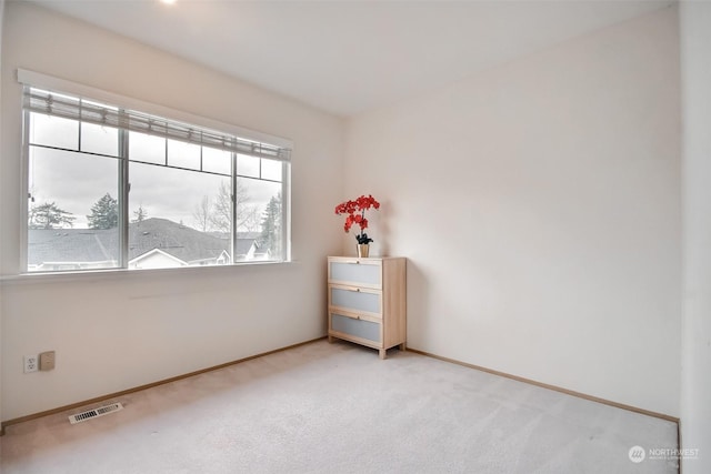 empty room with visible vents, carpet floors, and baseboards