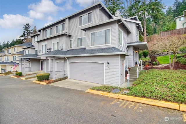 view of property with driveway, a shingled roof, a chimney, a garage, and a residential view