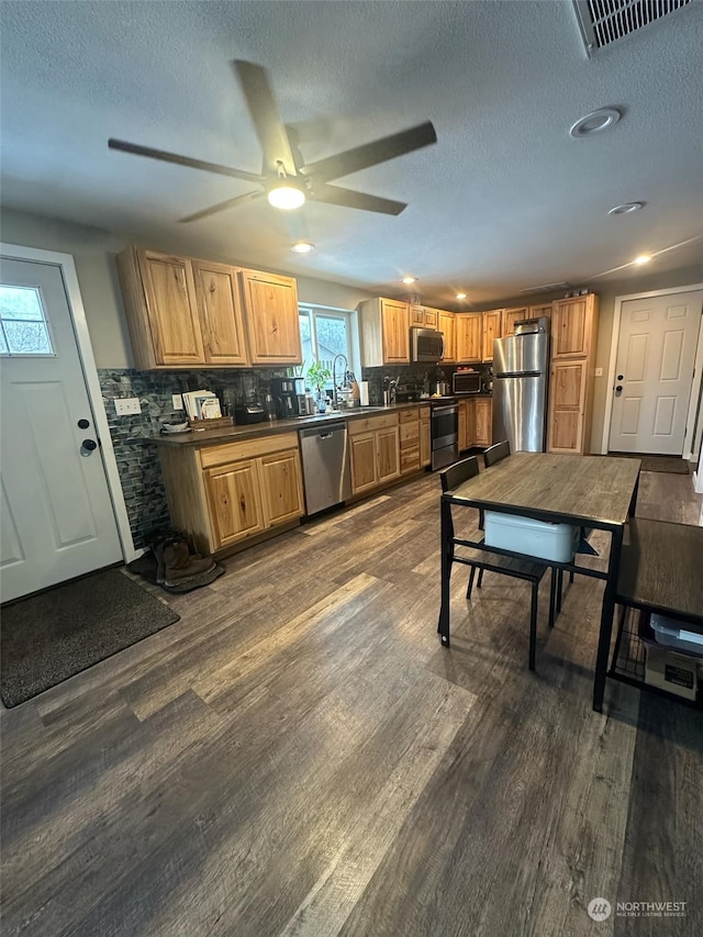 112 Haynes, Packwood, WA 98361 - kitchen featuring visible vents, dark countertops, appliances with stainless steel finishes, dark wood-style flooring, and backsplash