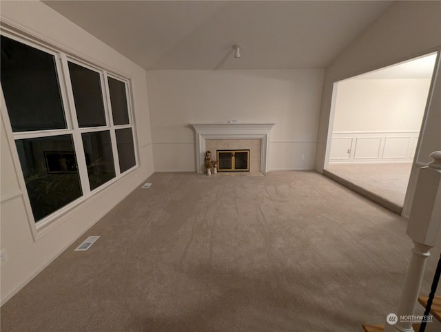 unfurnished living room with vaulted ceiling, carpet, and a fireplace