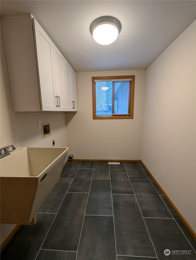 laundry area with cabinets, sink, washer hookup, and a textured ceiling