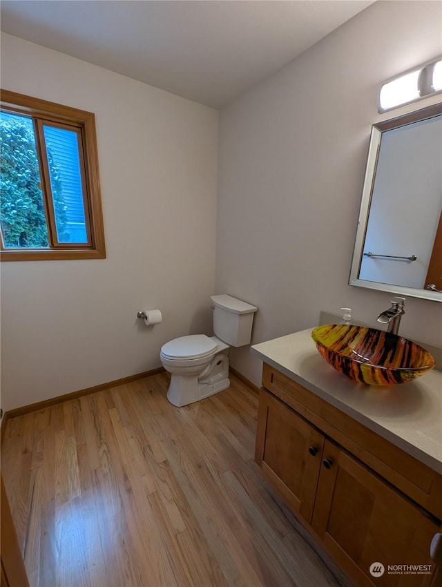 bathroom with vanity, toilet, and hardwood / wood-style floors