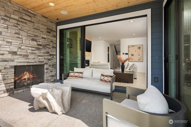 carpeted living room featuring wooden ceiling and an outdoor stone fireplace