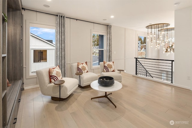 living area featuring an inviting chandelier and light hardwood / wood-style flooring