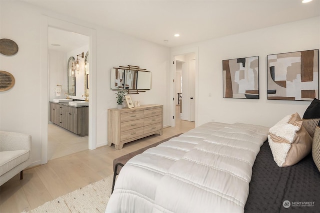 bedroom featuring sink, light hardwood / wood-style floors, and ensuite bathroom