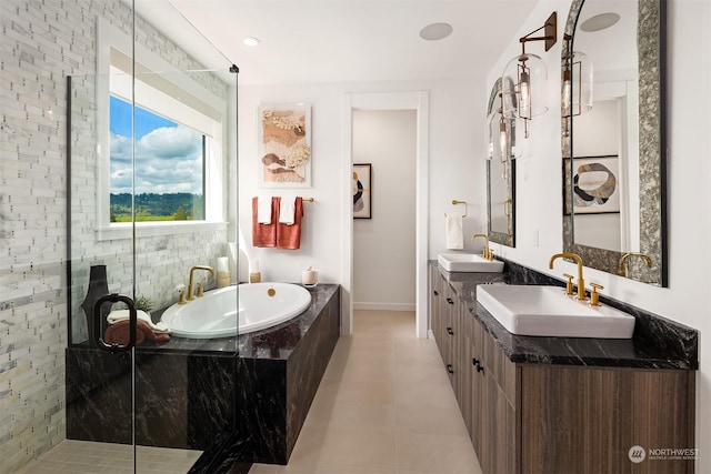 bathroom with vanity, a relaxing tiled tub, and tile patterned floors