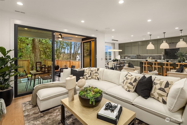 living room featuring ceiling fan and light wood-type flooring