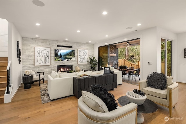 living room featuring a stone fireplace and light hardwood / wood-style floors