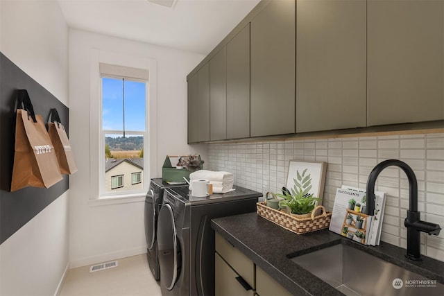 laundry area featuring cabinets, sink, and washing machine and clothes dryer