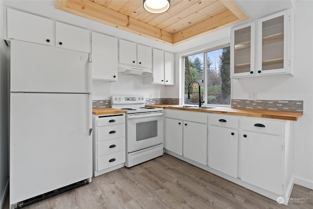 kitchen featuring wood counters, sink, white cabinetry, a tray ceiling, and white appliances