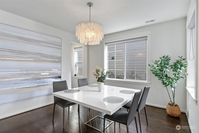 dining room featuring dark hardwood / wood-style flooring and a notable chandelier