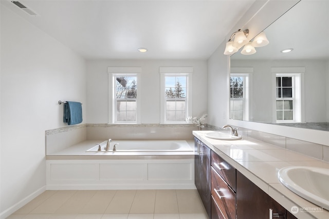 bathroom with vanity, tile patterned flooring, and a tub