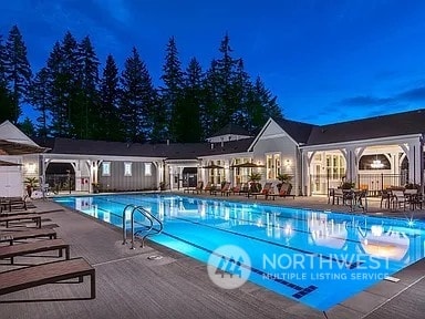 pool at night featuring a patio